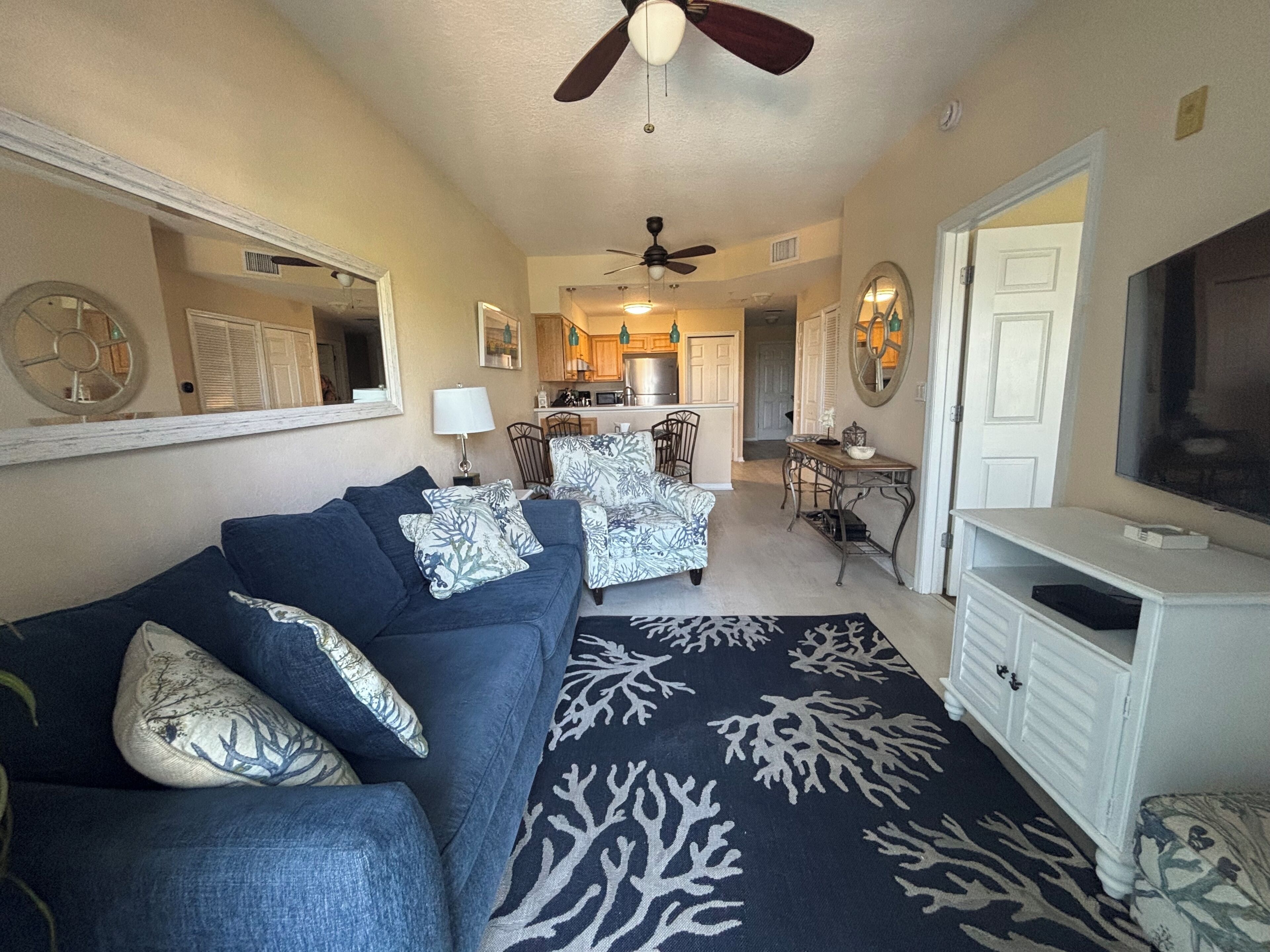 A living room with a sofa, a television, and a dining area with chairs and a table.