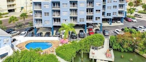 Un hotel de varios pisos con piscina, estacionamiento y muelle.