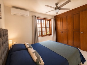 A bedroom with a bed, a ceiling fan, a window with curtains, and a wardrobe. - Rooftop Ocean views, great outdoor space,  A/C,  prime location, gated, firepit (Ensenada)