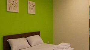 A bedroom with a bed, green walls, and two wall-mounted air conditioning units. - The Moonlight Resort (Ban Chang)