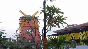 A garden with stepping stones, a windmill, and potted plants. - The Moonlight Resort (Ban Chang)