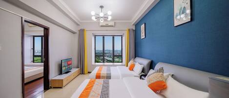 A modern hotel room with a large bed, a sofa, a TV, and a view of the city.