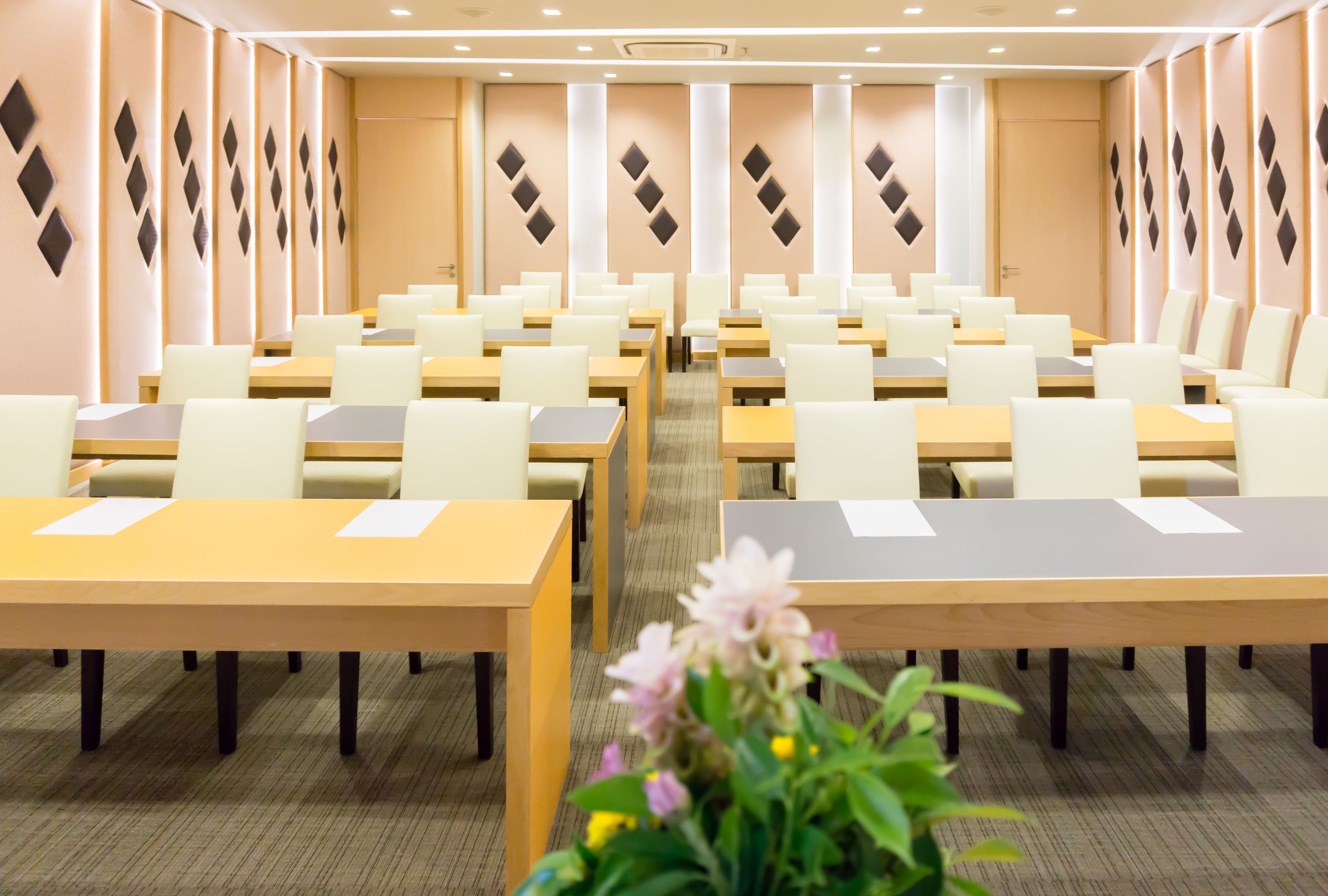 Uma sala de conferências com várias mesas e cadeiras dispostas em fileiras.