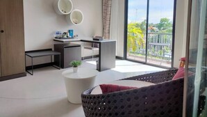 Una sala de estar moderna con sofá, una mesa redonda, un escritorio y un balcón con vistas.