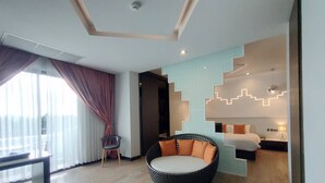 Una habitación de hotel moderna con una silla redonda negra y naranja, una cama con ropa de cama blanca y un diseño de pared con iluminación original.