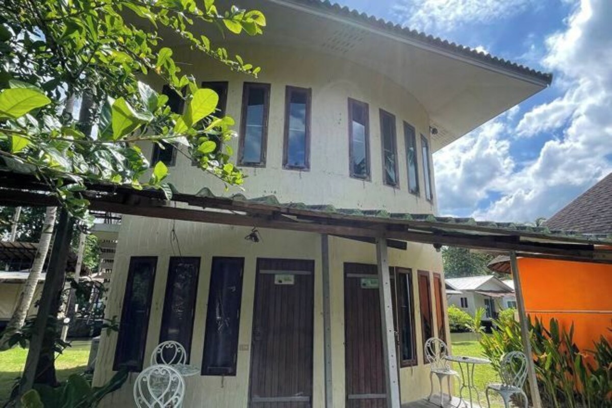 A two-story building with multiple windows and a covered porch area.