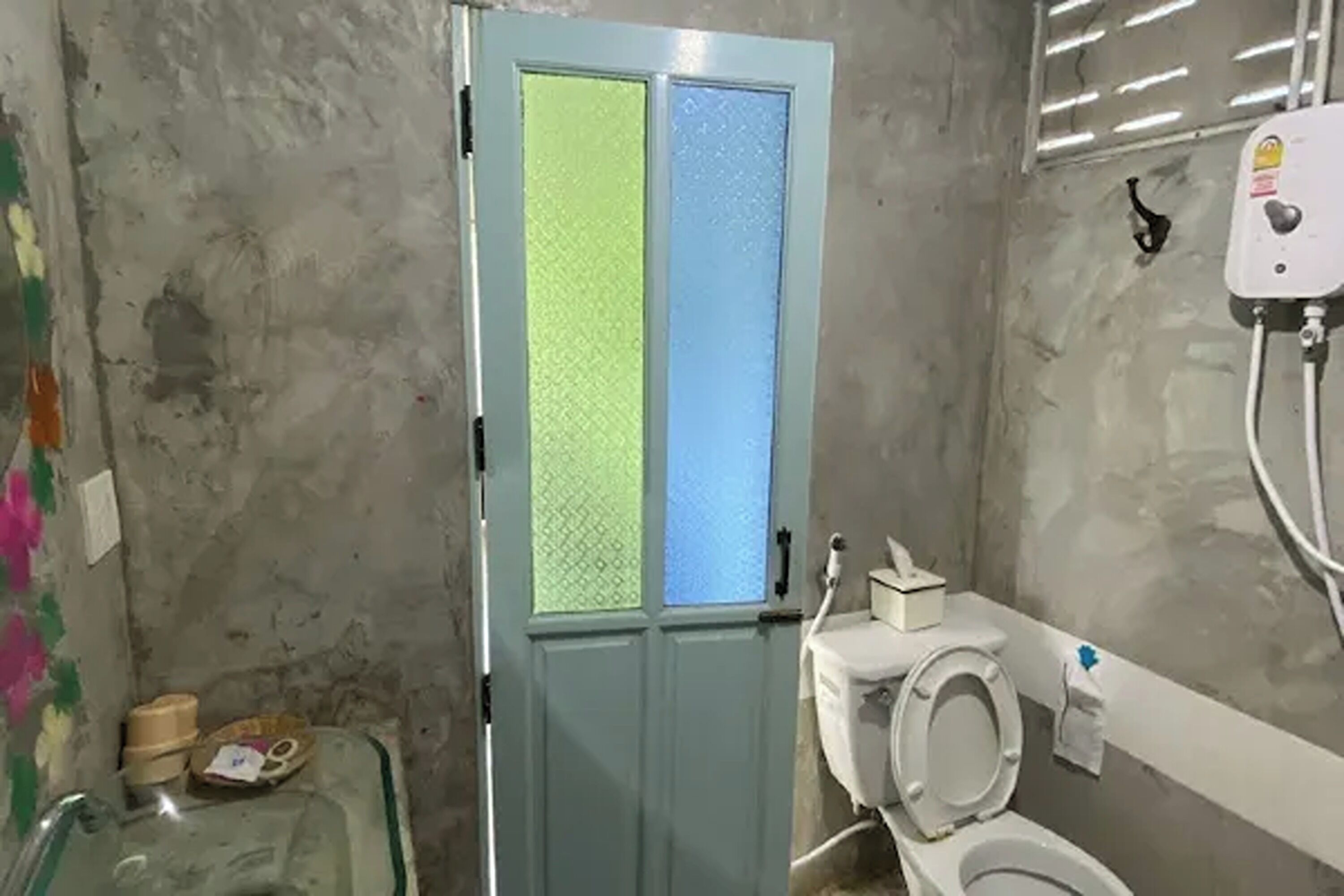 Une salle de bain avec des toilettes, un lavabo en verre et une douche.