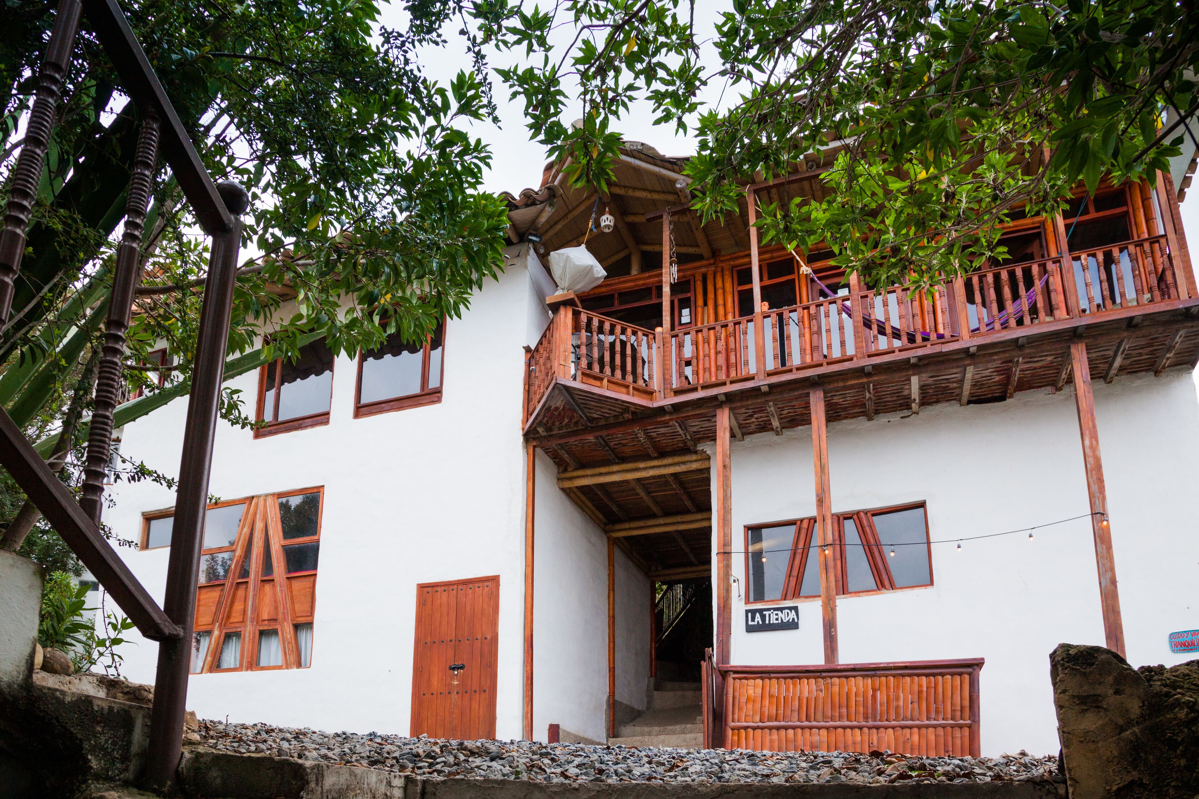 A two-story building with a wooden balcony, a staircase, and a sign reading "LA TIENDA".