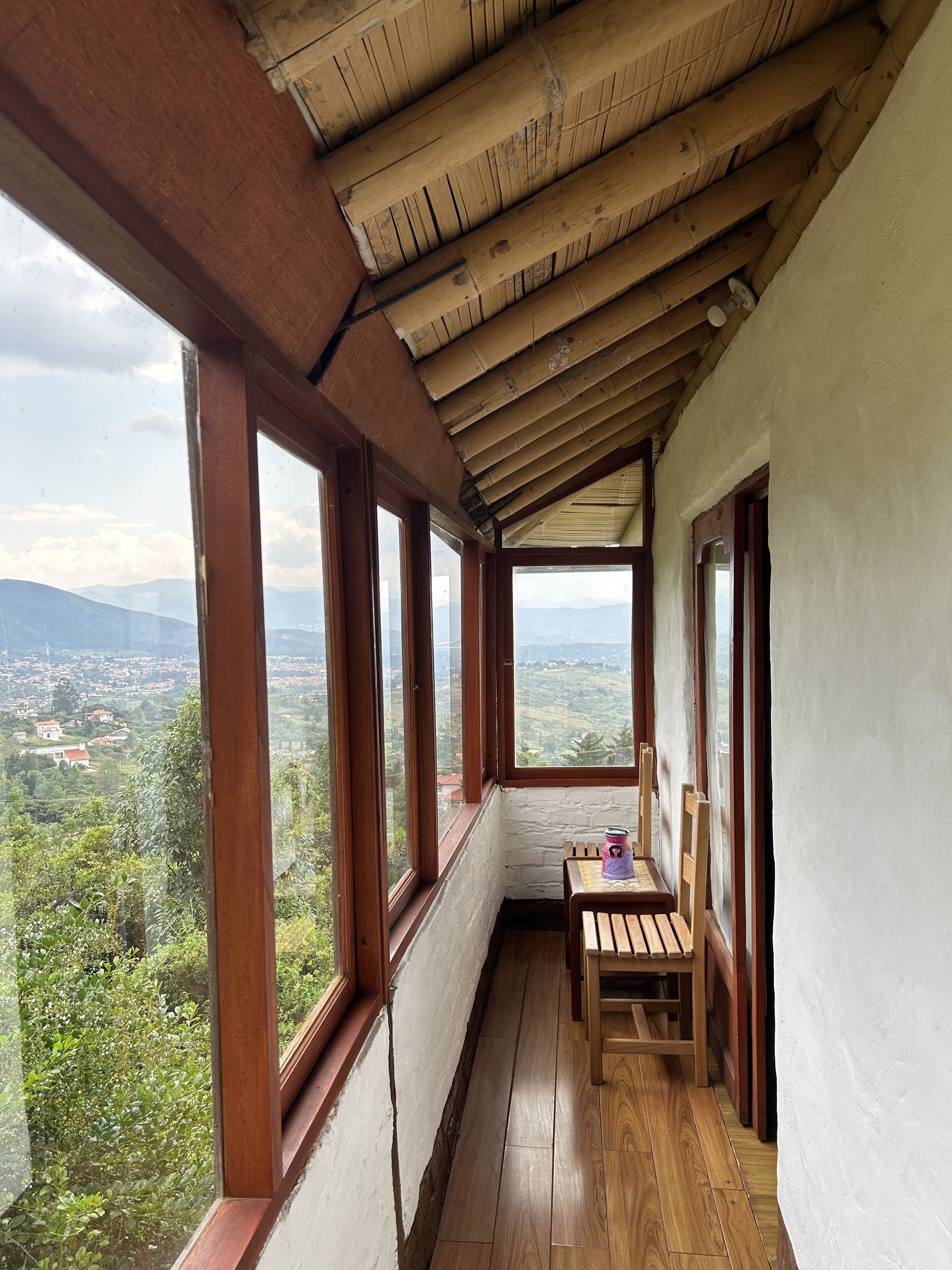 Un balcon en bois offrant une vue sur une vallée et des montagnes.
