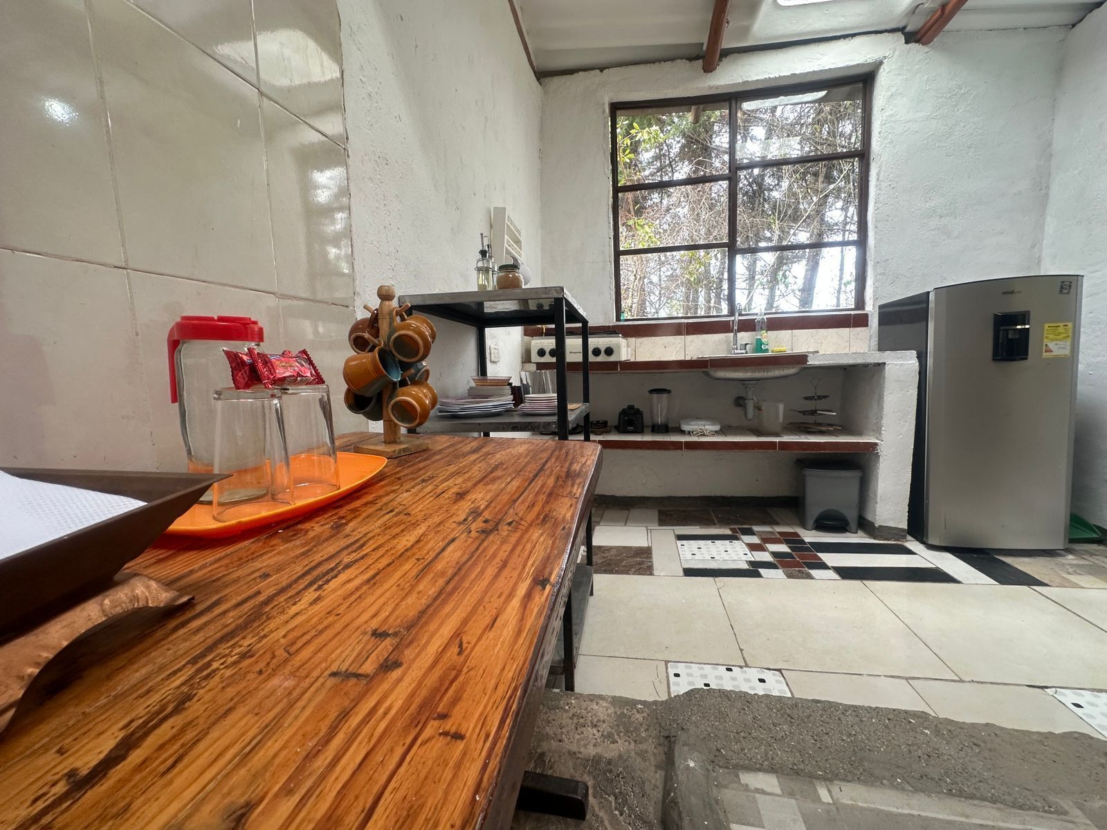 A kitchen with a wooden countertop, a sink, a stove, and a refrigerator.