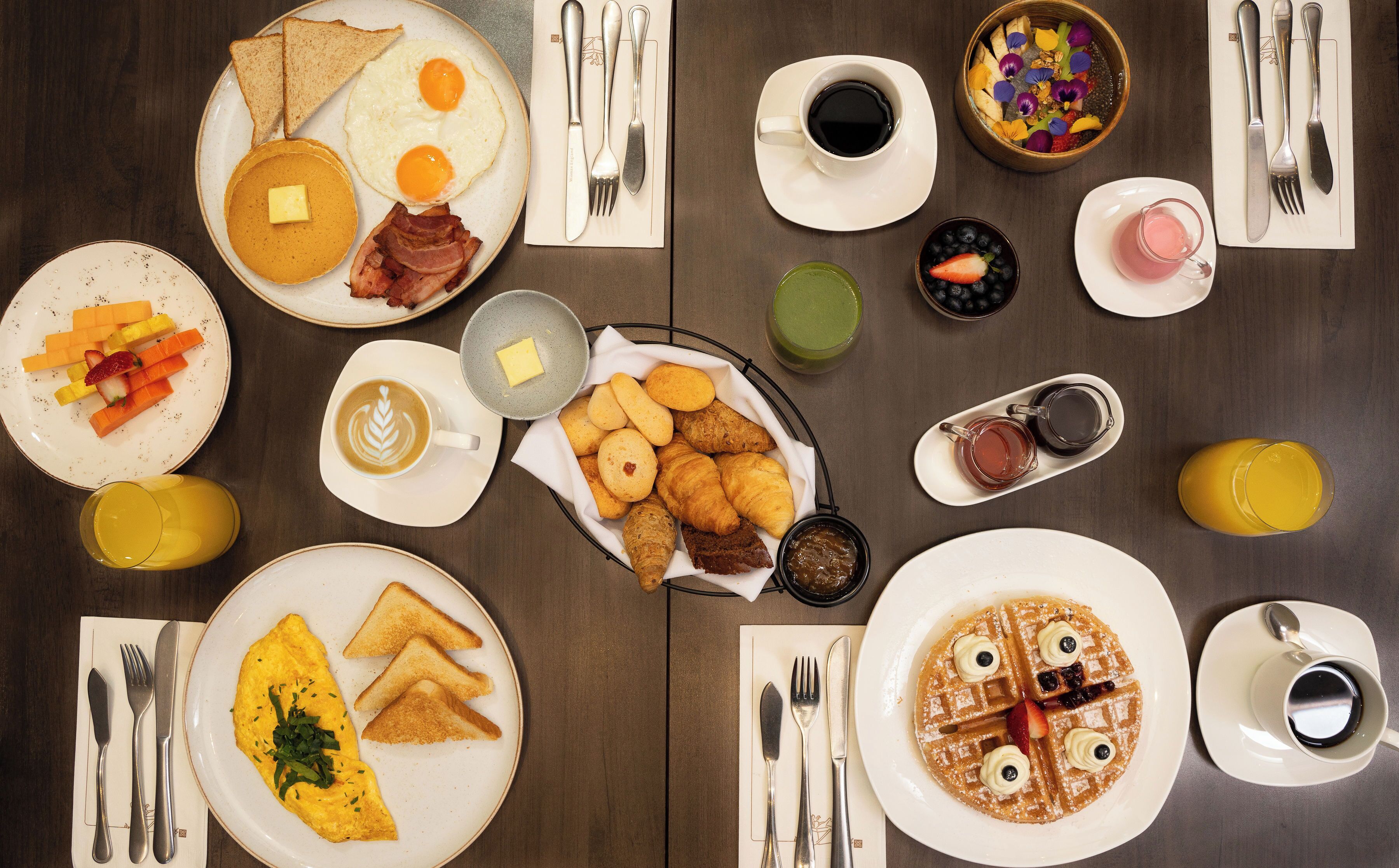 A breakfast buffet with various dishes and beverages.