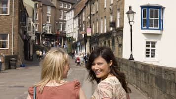 A street scene with buildings, a lamp post, and people walking.