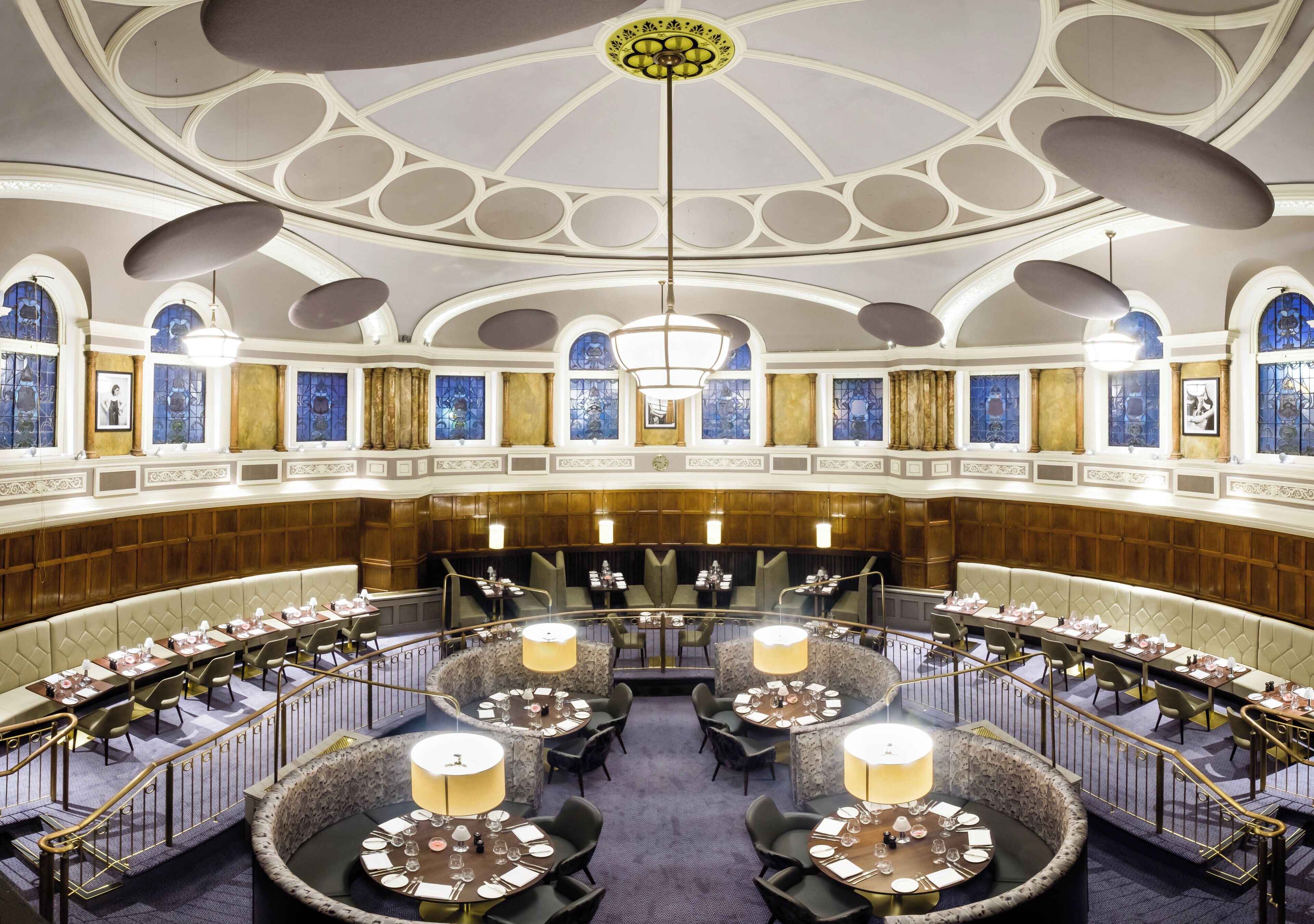 Un salón imponente con techo alto, columnas ornamentadas y un candelabro central.