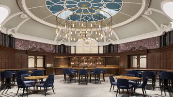 A bar area with a high ceiling, chandeliers, and marble walls.