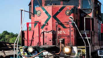 A red train engine with the number 2000 on its front, moving along the tracks.