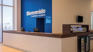 Mostrador de recepción con pared azul y un letrero que dice "Bienvenido te estamos esperando".