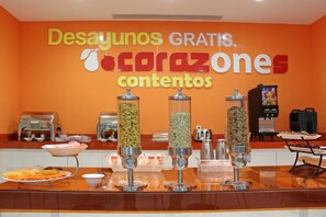 Un área de bufé para desayuno con un cartel que dice: "Desayunos gratis, cocrazones contenidos".