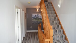 A staircase with striped carpet leading to a landing. - The Grange, Portrush. Deluxe holiday home, 8 beds, up to 12 guests, 6 bedrooms.  (Portrush)