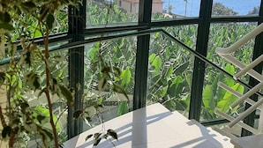A balcony with a view of the sea and mountains, a tiled floor, and a staircase. - Apartment "Vai Vem" -T2 on the island of Madeira - Portugal Tourism 32408 / AL (Madalena do Mar - Madeira)