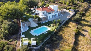 A modern house with a swimming pool, stone steps, and a garden.