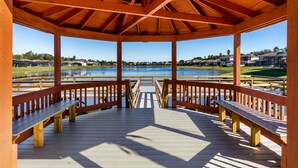 A wooden gazebo with a view of a lake and houses in the background. - KISSIMMEE VILLA ON GATED COMMUNITY WITH PRIVATE POOL & LAKE VIEWS! (Kissimmee)