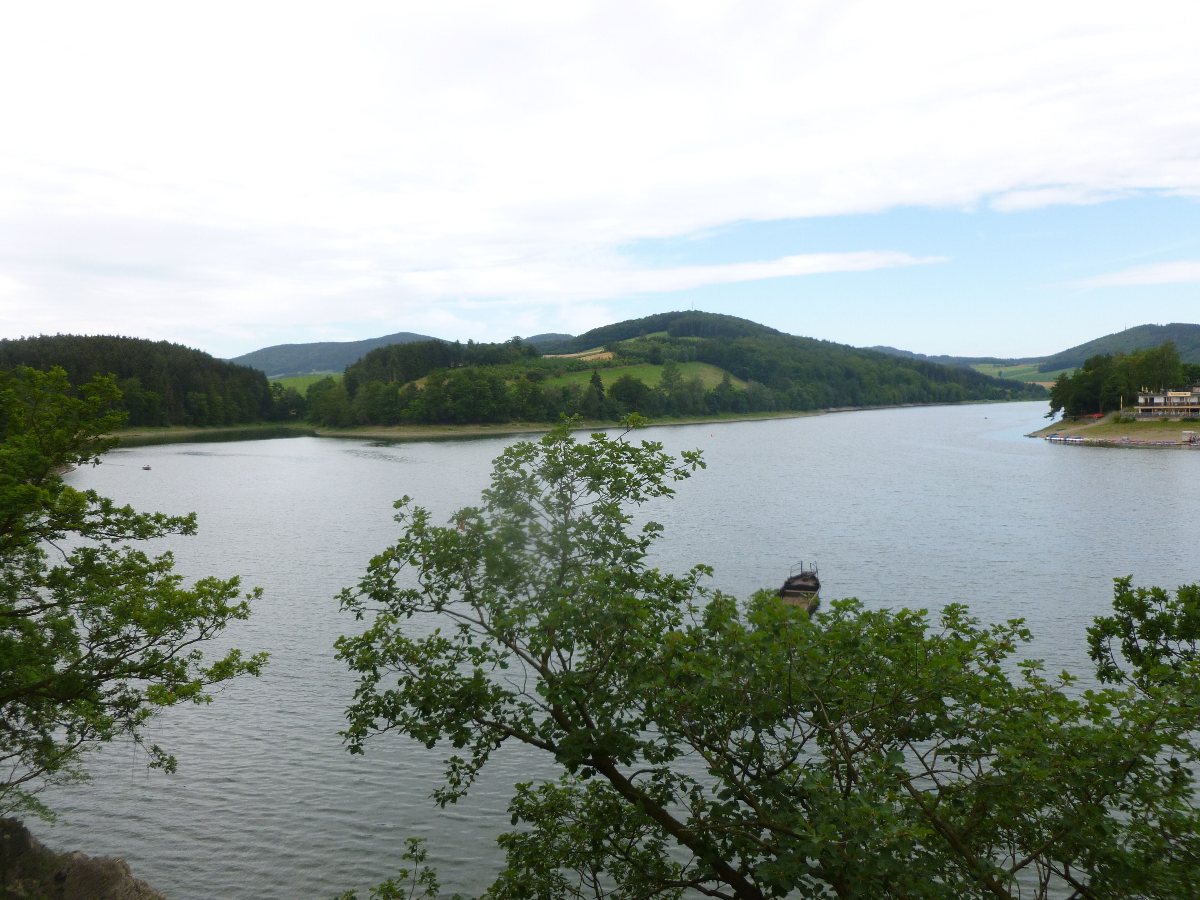 Un lago tranquilo con una pequeña isla y un edificio a la derecha.