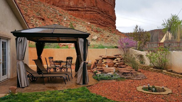 Une terrasse dotée d’un belvédère, de mobilier d’extérieur et d’un jardin de rocaille.