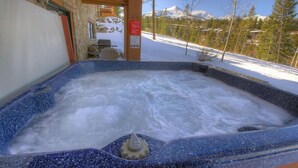 A hot tub with a stone exterior, a wooden roof, and a view of snow-covered mountains. - Super Ski Pad - True Ski-In/Ski-Out Retreat. Private Hot Tub. Walk to Adventure (Breckenridge)
