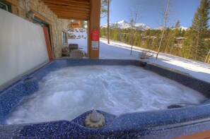 Relax in a serene hot tub under a sheltered pergola with breathtaking mountain views.
