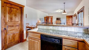 A kitchen with wooden cabinets, a granite countertop, and a dishwasher. - Super Ski Pad - True Ski-In/Ski-Out Retreat. Private Hot Tub. Walk to Adventure (Breckenridge)