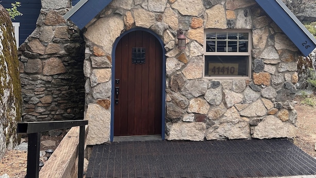 A stone house with a blue roof and a wooden door. - Adorable Mountain Getaway (Shaver Lake)