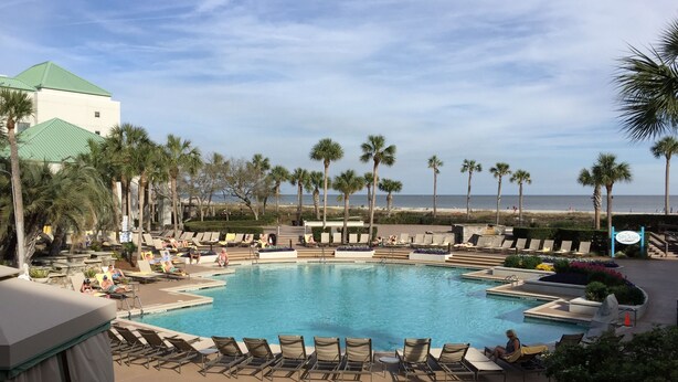 A pool area with multiple lounge chairs and a view of the beach. - Ocean Palms-Heaven is Being At The Beach-Free Golf/Tennis (Hilton Head Island)