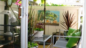 A patio area with a table, chairs, an umbrella, and various plants. - Relax in Style in Carlsbad's Best Location (Carlsbad)