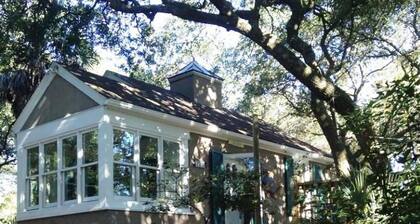 Romanttinen, kodikas mökki suojissa elää tammia ja palmuja, korttelin päässä rannalta.