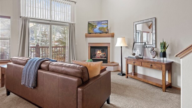 A living room with a fireplace, a sofa, a coffee table, and a lamp.