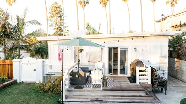 A patio with outdoor furniture, a covered seating area, and a view of the backyard. - The Family Beach House  (San Diego)