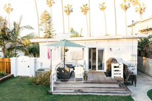 A patio with outdoor furniture, a covered seating area, and a view of the backyard. - The Family Beach House  (San Diego)