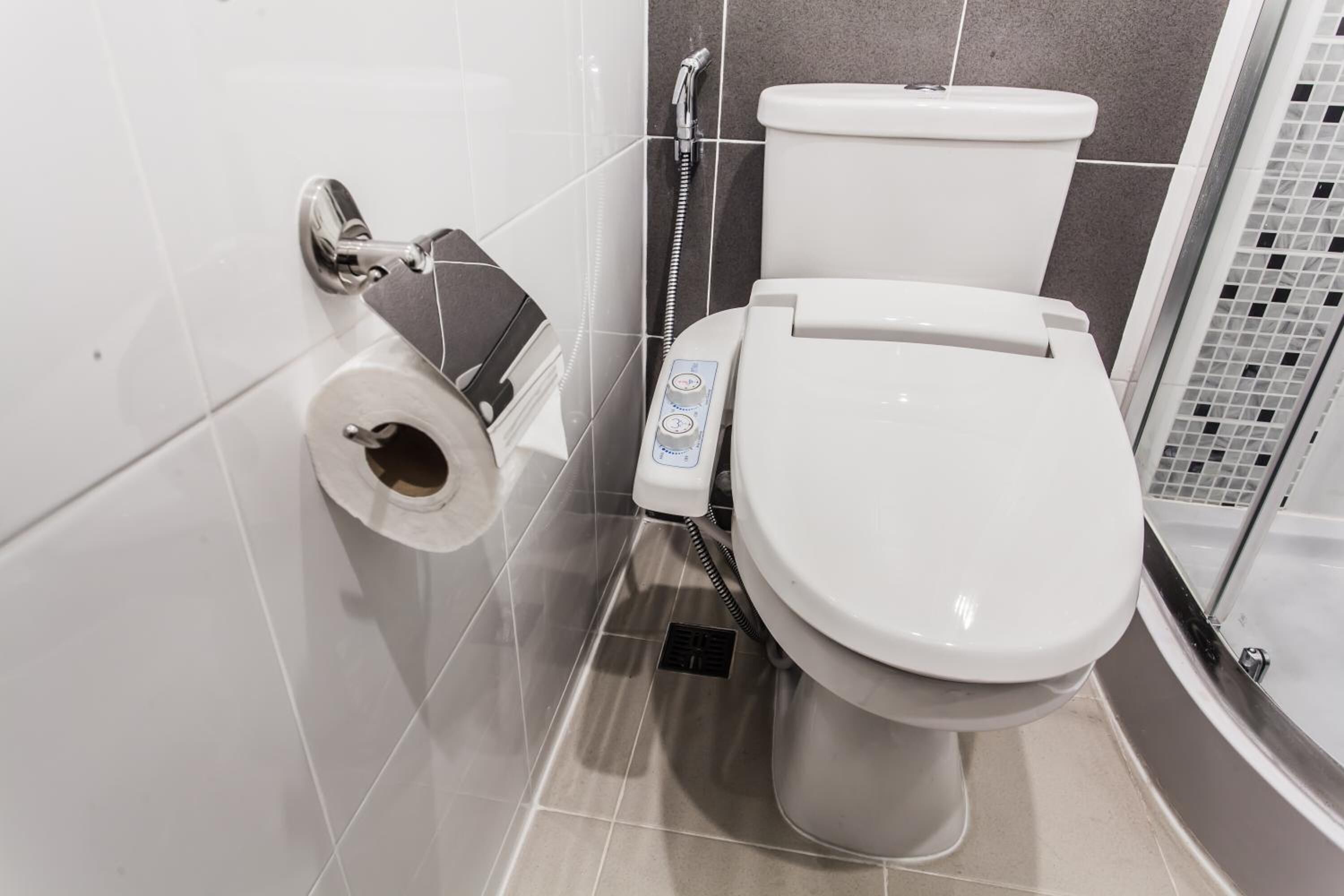 Un baño moderno con inodoro, bidé y zona de ducha.