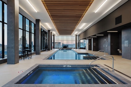Indoor pool, open 7:00 AM to 11:00 PM, pool loungers. Hôtel AC Montréal Centre-ville