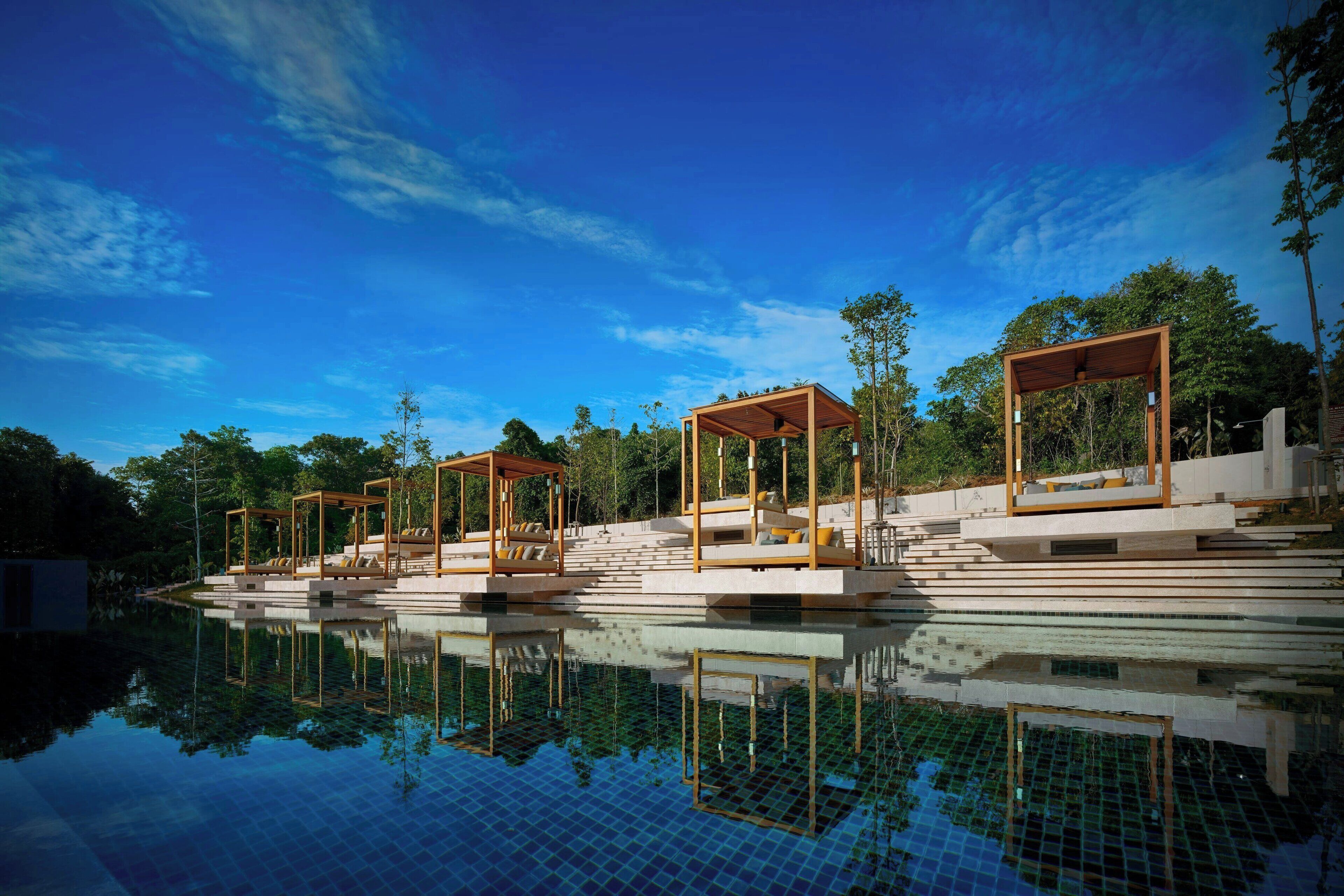 A modern pool area with wooden structures and steps leading into the water.