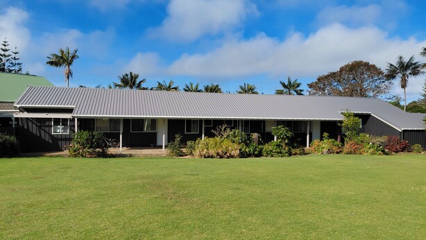 A two-story building with a flat roof and a covered porch. - Fletcher Christian Apartments (Norfolk Island)