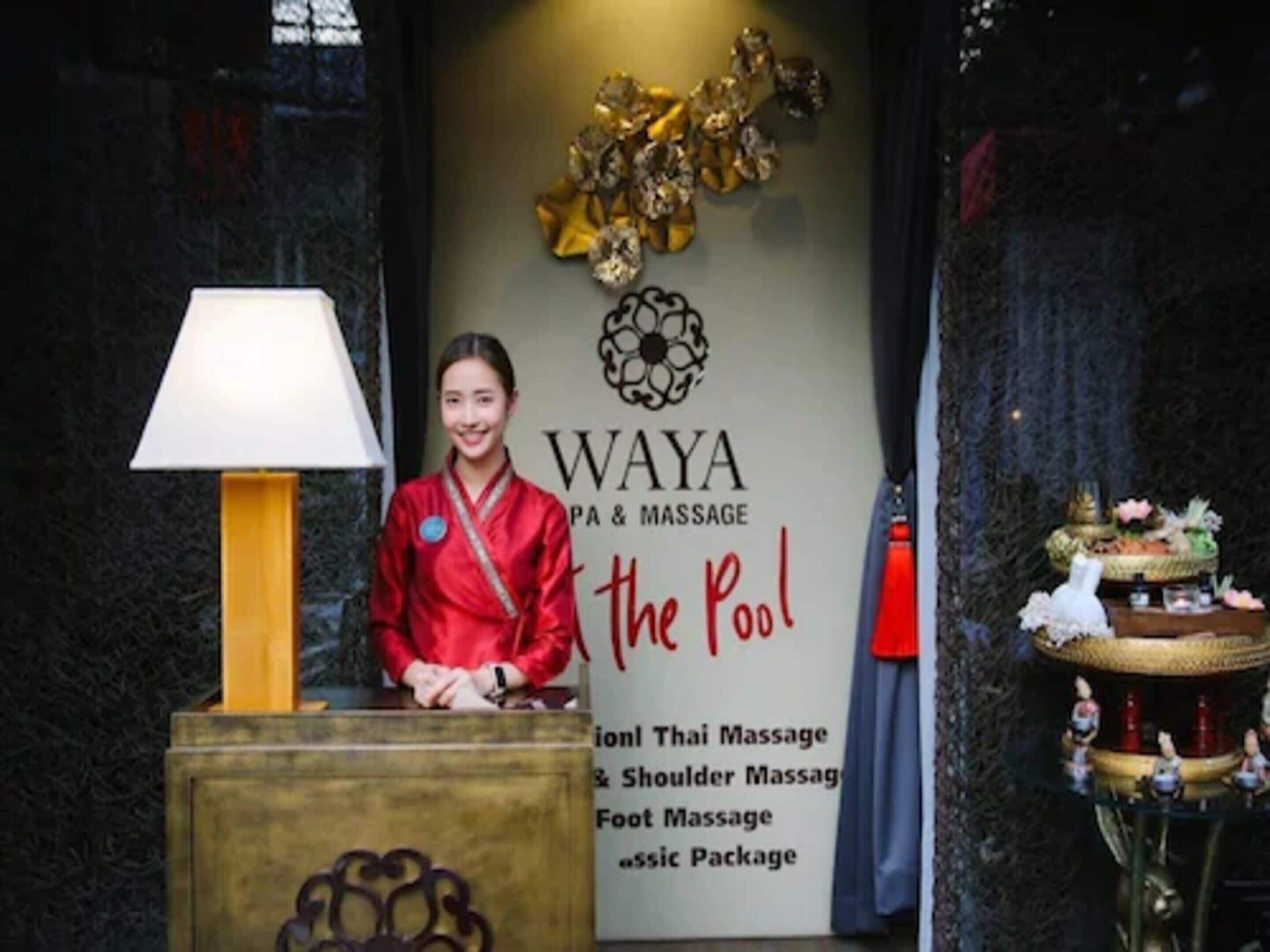 A reception area with a sign for WAYA PA & MASSAGE, offering services like Thai Massage, Shoulder Massage, and Foot Massage.