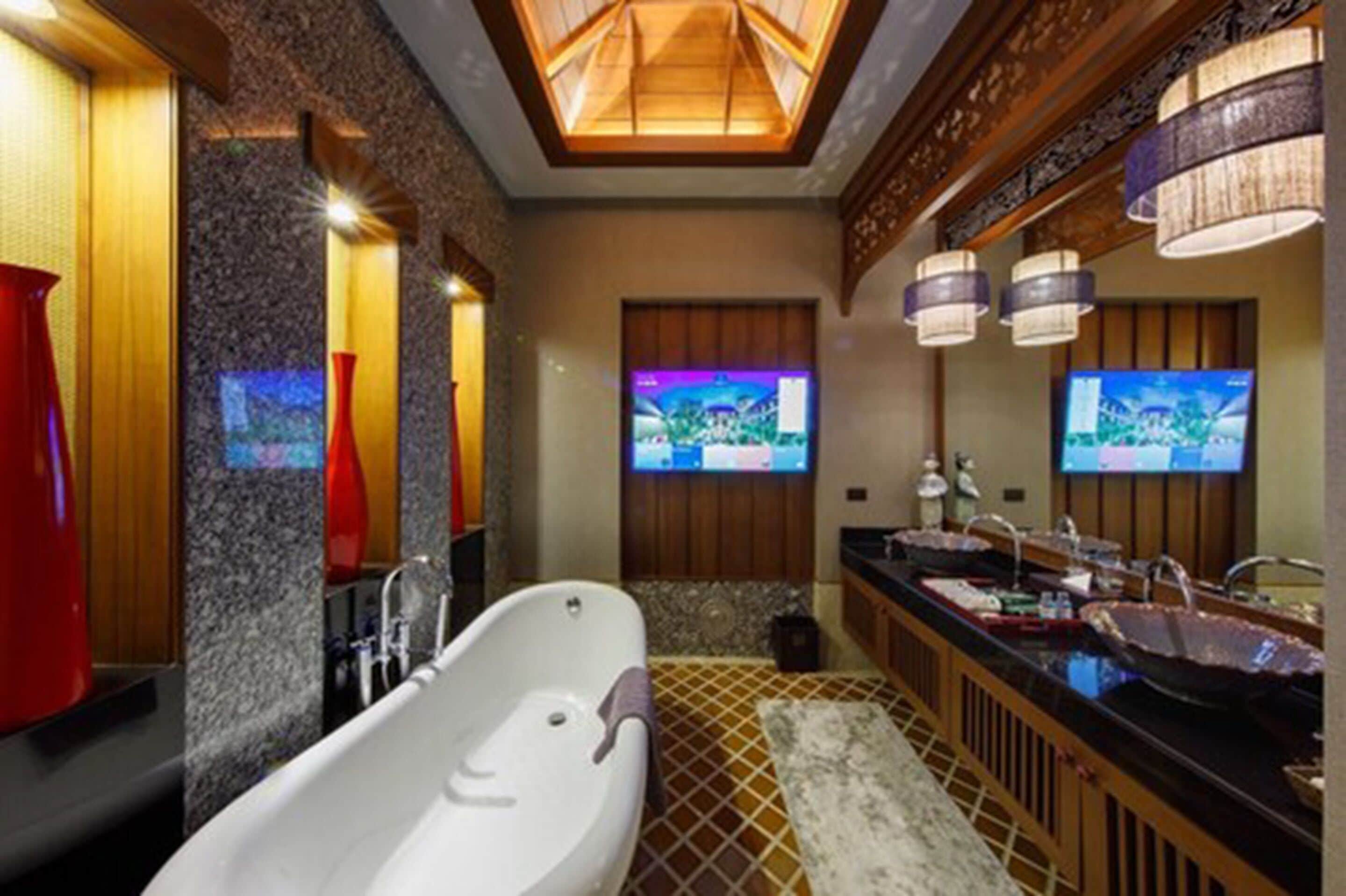 A modern bathroom with a freestanding bathtub, dual sinks, and a large mirror.
