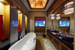 A modern bathroom with a freestanding bathtub, dual sinks, and a large mirror.