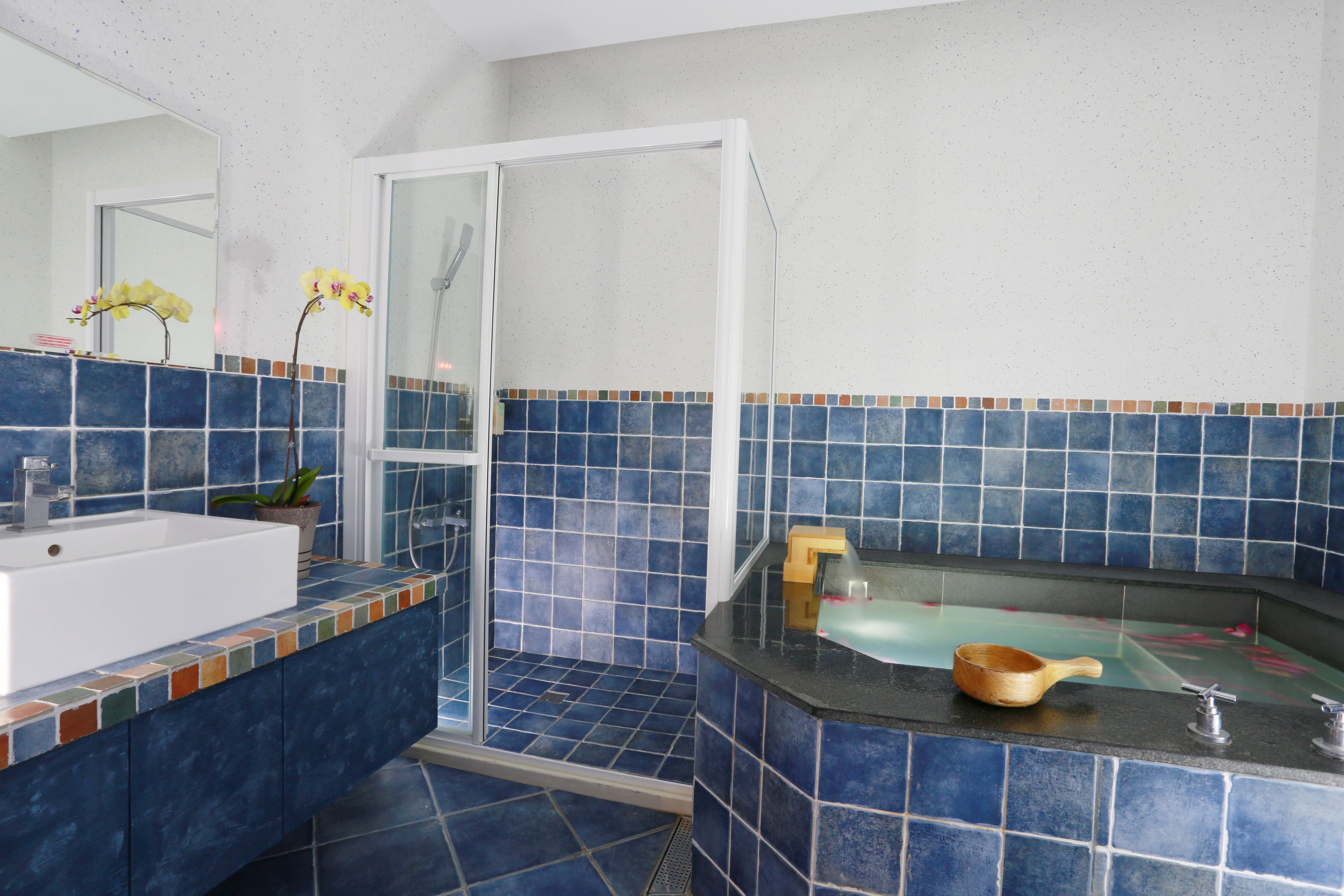 A bathroom with a white sink, a bathtub, and a shower area.