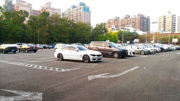 A parking lot with multiple cars and buildings in the background.
