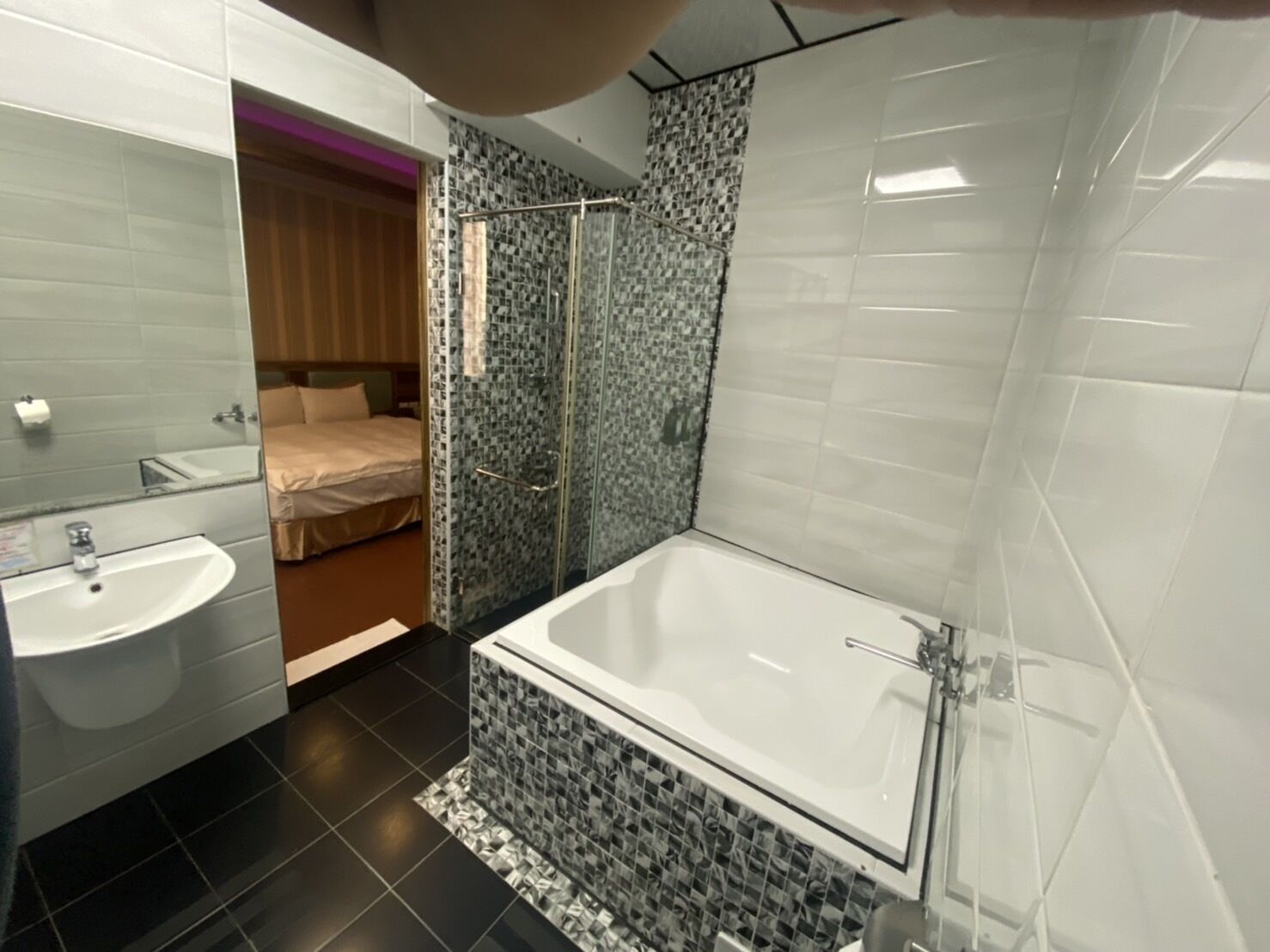 Un baño moderno con una bañera grande, cabina de ducha con mampara de cristal y zona separada para el lavamanos.