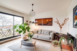 Un salon moderne avec un canapé, une table basse et des plantes en pot.
