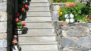 A stone staircase leading to a wooden door, surrounded by potted flowers and a stone wall. -  BEAUTIFUL GITE 4 PEOPLE  (Bozel)