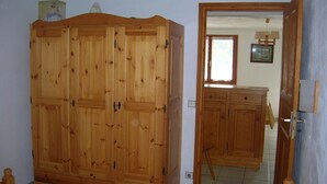 A room with a large wooden wardrobe, a small cabinet, and a mirror. -  BEAUTIFUL GITE 4 PEOPLE  (Bozel)